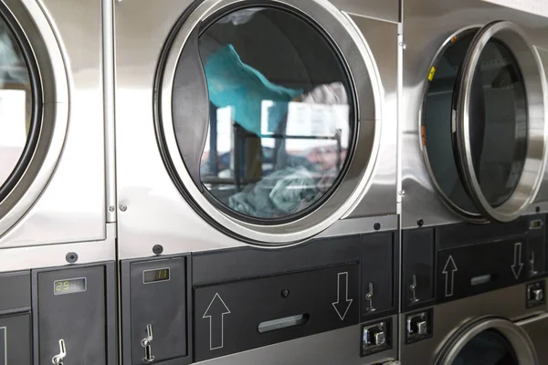 washing machines with clothes inside at laundromat