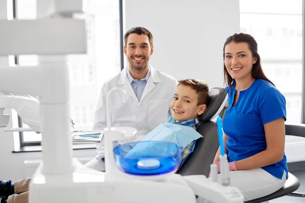 Dentistas e paciente infantil na clínica odontológica — Fotografia de Stock