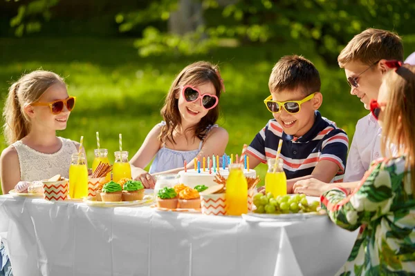 Happy kids with cake on birthday party in summer — Stock Photo, Image
