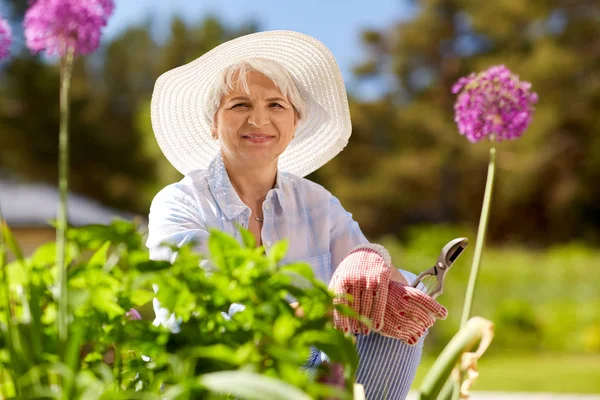 Senior femme avec taille de jardin et fleurs — Photo