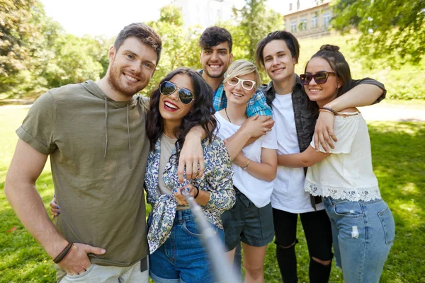 Friends taking picture by selfie stick at summer — Stock Photo, Image
