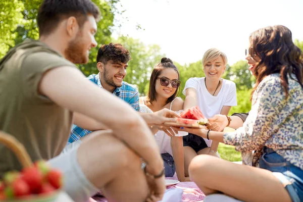 Happy vrienden delen van watermeloen op zomerpicknick — Stockfoto