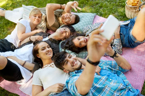 Amigos tomando selfie em piquenique no parque de verão — Fotografia de Stock