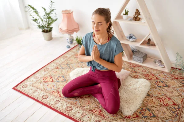 Женщина медитирует в позе лотоса в студии йоги — стоковое фото
