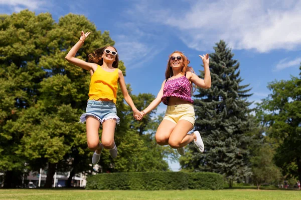 Feliz adolescente niñas saltar en verano parque —  Fotos de Stock