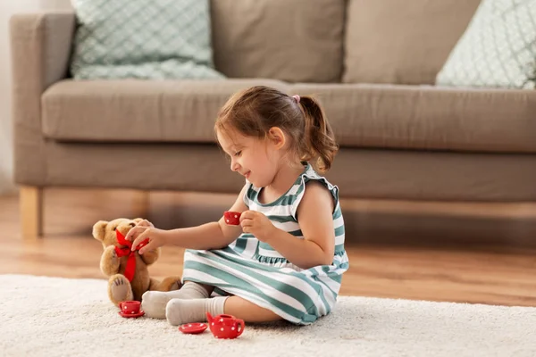 Kleines Mädchen spielt zu Hause mit Spielzeug-Tee-Set — Stockfoto