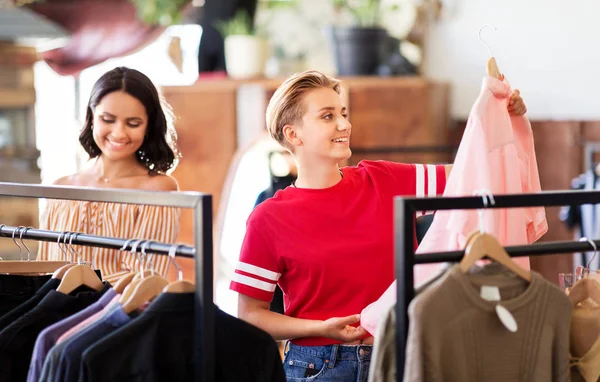 Mulheres escolhendo roupas na loja de roupas vintage — Fotografia de Stock