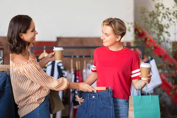 Счастливые женщины с кофе в винтажном магазине одежды — стоковое фото
