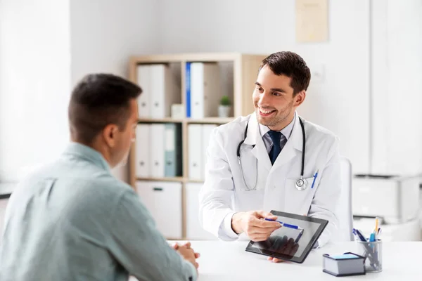Doctor with tablet computer and patient at clinic — Stock Photo, Image