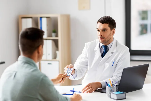Doctor giving medicine to male patient at hospital — Stock Photo, Image
