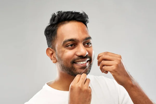Uomo indiano con denti di pulizia filo interdentale — Foto Stock