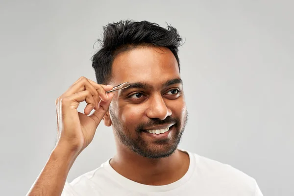 Indischer Mann mit Pinzette Pinzette, die Augenbrauen frisiert — Stockfoto