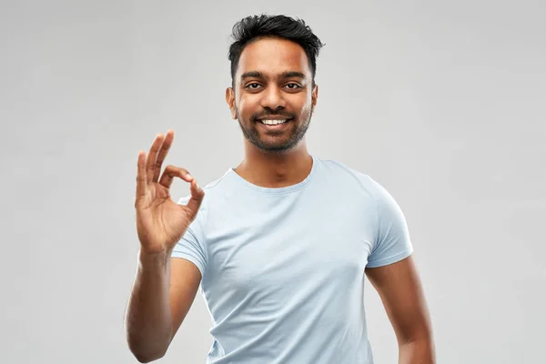 Счастливый индийский мужчина в футболке, показывающий знак ладони — стоковое фото