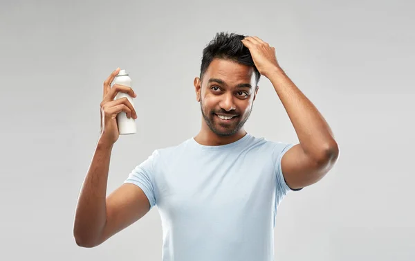 Uomo indiano sorridente applicare lacca sui capelli grigio — Foto Stock