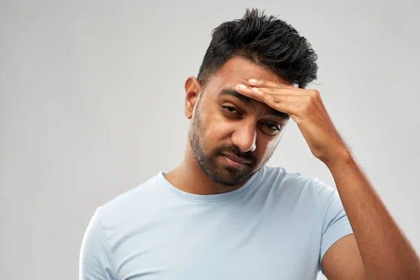 Unhappy indian man suffering from headache Stock Picture
