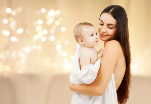 Primer plano de la madre con el bebé sobre las luces de Navidad —  Fotos de Stock
