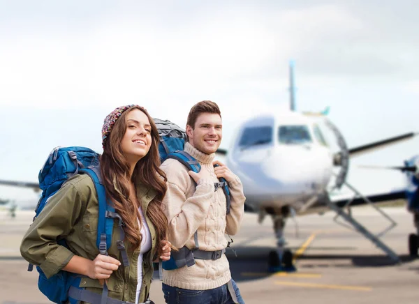 Casal de turistas com mochilas sobre avião — Fotografia de Stock