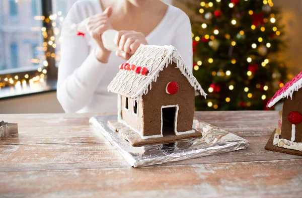 Woman making gingerbread houses on christmas — Stock Photo, Image