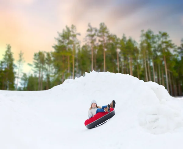 Menina adolescente feliz deslizando para baixo colina no tubo de neve — Fotografia de Stock