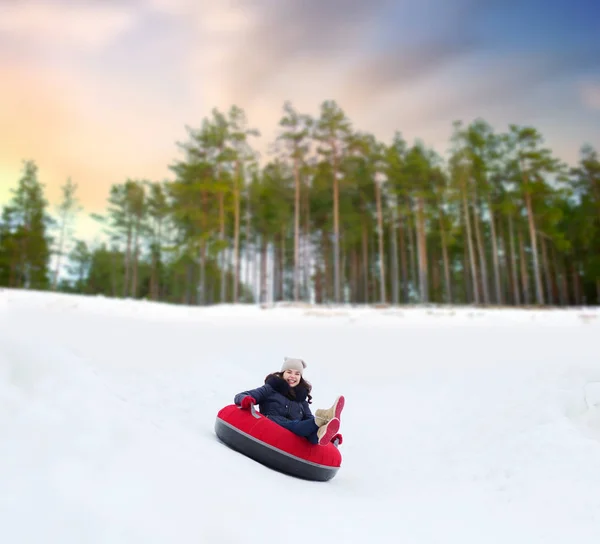 Felice ragazza adolescente scorrevole giù collina sul tubo della neve — Foto Stock