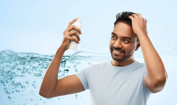 Uomo indiano sorridente applicare lacca sui capelli grigio — Foto Stock