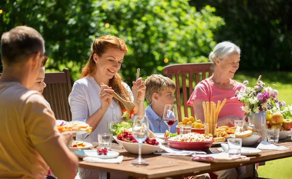 O familie fericită care ia cina sau o petrecere în grădină de vară — Fotografie, imagine de stoc