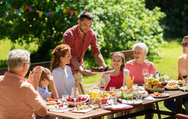 Ευτυχισμένη οικογένεια έχοντας δείπνο ή καλοκαιρινό πάρτι στον κήπο — Φωτογραφία Αρχείου