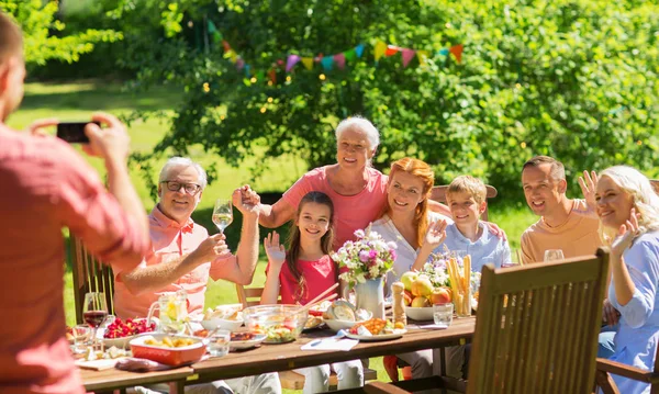 Happy family photographing at dinner in garden — Stock Photo, Image