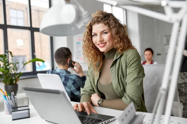 Счастливая женщина с компьютером в офисе — стоковое фото