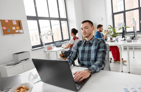 Homem criativo com laptop trabalhando no escritório — Fotografia de Stock