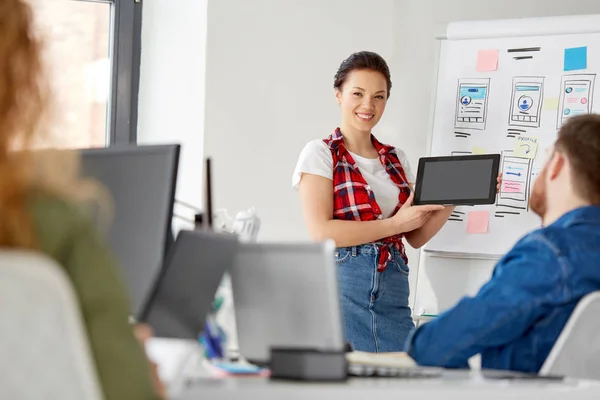 Mulher mostrando tablet pc para a equipe criativa no escritório — Fotografia de Stock
