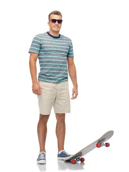 Smiling young man with skateboard over white — Stock Photo, Image