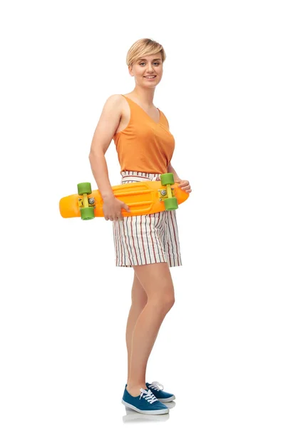 Smiling teenage girl with skateboard over white — Stock Photo, Image