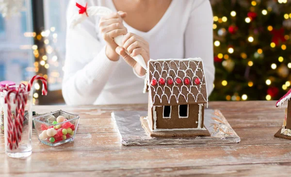 クリスマスのジンジャーブレッドの家を作る女性 — ストック写真