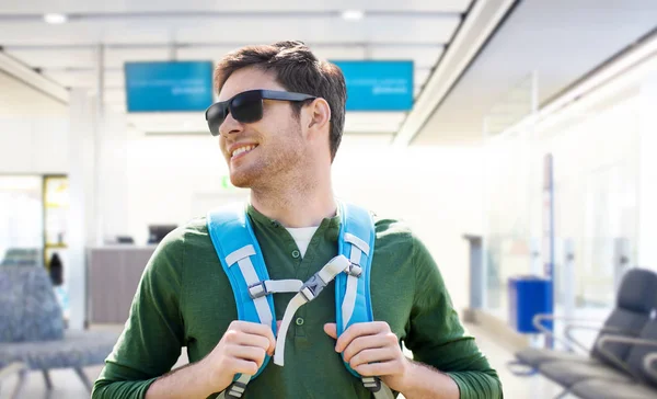 Glimlachende man met rugzak over luchthaventerminal — Stockfoto