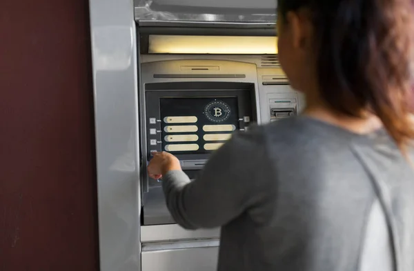 Vrouw op de ATM-machine met bitcoin pictogram op scherm — Stockfoto