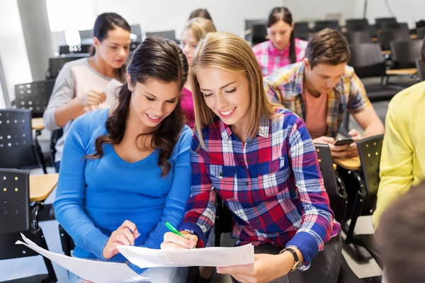 Nöjd student flickor med tester på föreläsningssal — Stockfoto