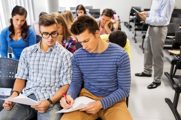 Groep studenten met papieren in collegezaal — Stockfoto
