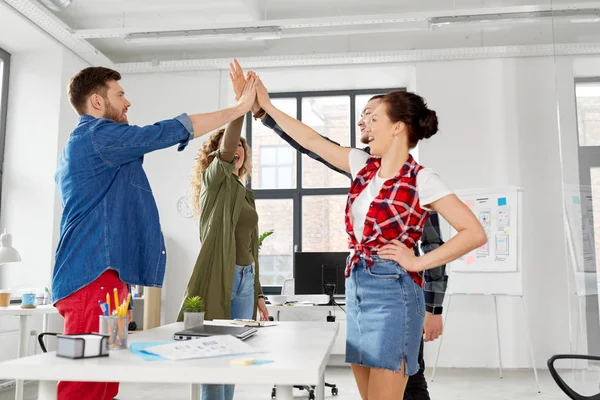 Lyckliga kreativa team att göra high five på kontor — Stockfoto