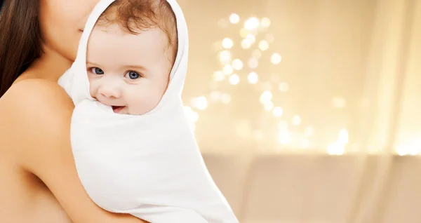 Primer plano de la madre con el bebé sobre las luces de Navidad — Foto de Stock