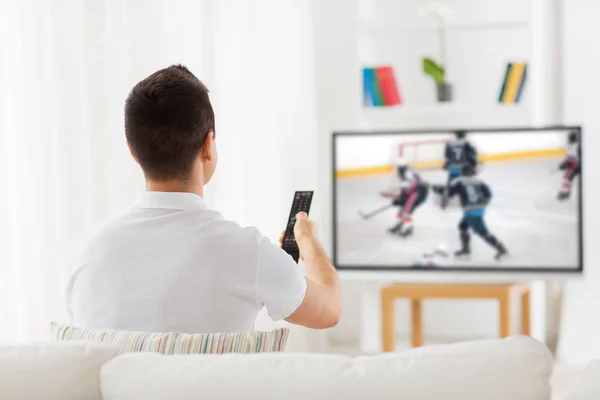 Człowiek ogląda mecz hokeja na tv w domu — Zdjęcie stockowe