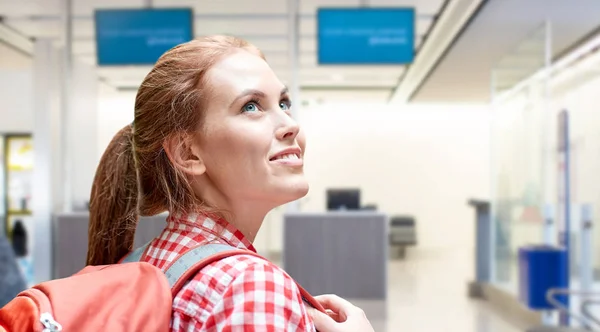 Молодая женщина с рюкзаком над терминалом аэропорта — стоковое фото