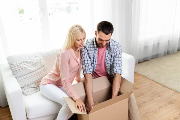 Happy couple with open parcel box at home — Stock Photo, Image