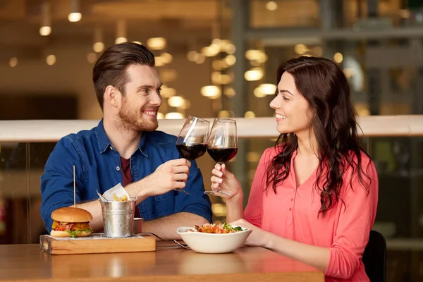 Pareja comiendo y bebiendo vino tinto en el restaurante — Foto de Stock