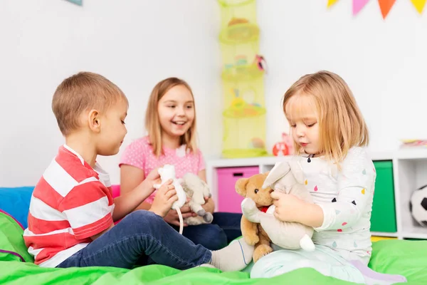 Niños felices jugando con juguetes suaves en casa —  Fotos de Stock