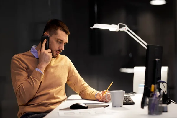 Business man calling on sartphone at night office — стоковое фото