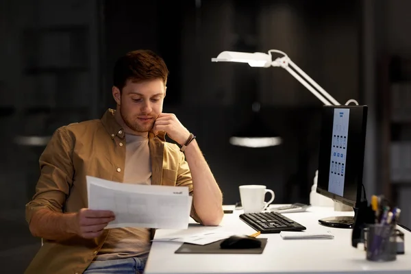 Tasarımcısı kağıtları ve gece ofiste bilgisayar ile — Stok fotoğraf