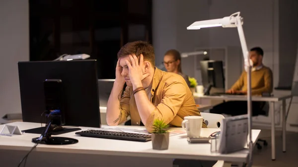 Gestresster Mann am Computermonitor im Nachtbüro — Stockfoto