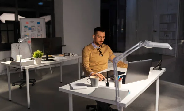 Дизайнер с компьютером и планшетом ручки в офисе — стоковое фото
