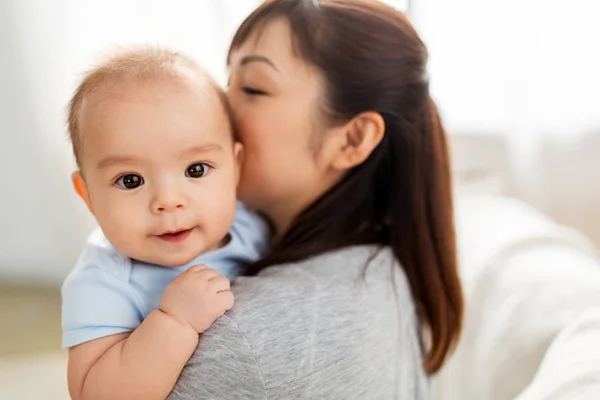 Close up de feliz mãe beijando bebê filho em casa — Fotografia de Stock